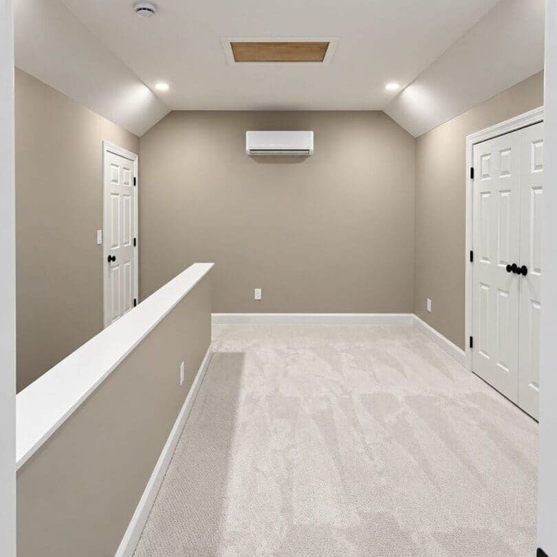 Finished attic room with carpet, sloped ceiling, recessed lights, closet doors, and a wall-mounted mini-split